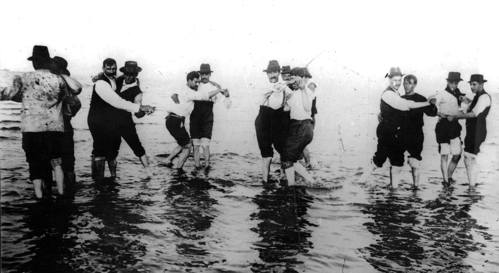 Hombres bailando tango en el río 1904